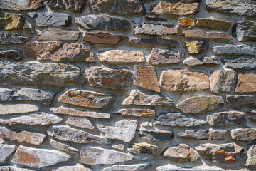 Photograph showcasing rugged limestone and granite wall with moss and shadow play for artistic projects