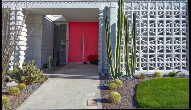 Mid-century modern home entrance with pink double doors and breeze blocks

