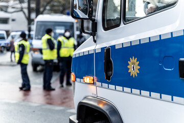 Blue police car on the side of a political rally or demonstration. The badge of the german...