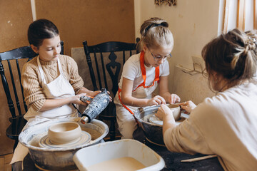 Children learning pottery craft during workshop class