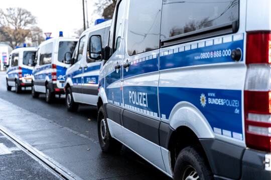 Riot police cars are standing on the side of a political rally or demonstration against the corona laws of the german government.