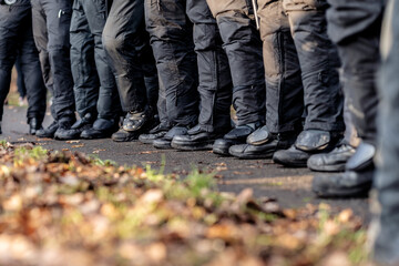 Black boots of german police officers in leaves. The safety shoes are laced tightly.