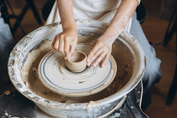 Child hands crafting pottery on a wheel