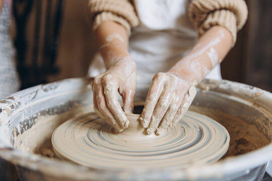 Children learning pottery craft on a spinning wheel