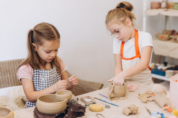 Young girls enjoying pottery workshop learning new craft skills