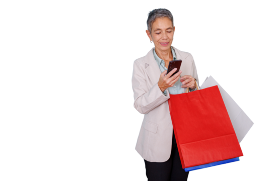 Senior woman shopping online using smartphone and carrying colorful bags, retail experience, happy customer