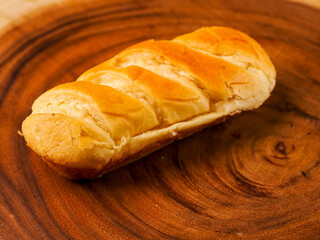 French soft and golden brioche roll on wooden background. Premium top quality pastry product. Fine and delicate dessert.