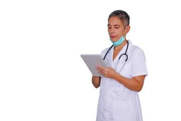 Mature female doctor or nurse in a white coat with stethoscope, using a tablet, face mask resting on chin. Clear background