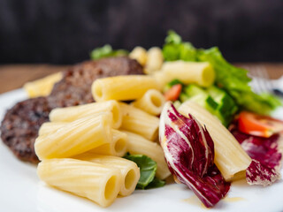 Meal with two tasty burgers, pasta and fresh salad and no sauce. Diet dinner for people with high...