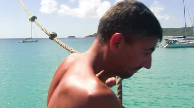 A man jumps overboard with a rope