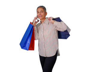 Senior woman walking, smiling, talking on smartphone, carrying colorful shopping bags on transparent background
