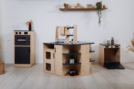 Modular wooden play kitchen set in kids room, eco toy furniture with shelves and sink