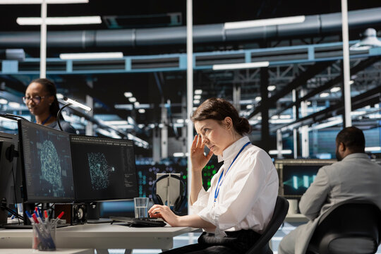 Overworked data center IT expert feeling headache while using artificial intelligence neural networks. Exhausted server farm developer having migraine from working too hard, using AI on computer