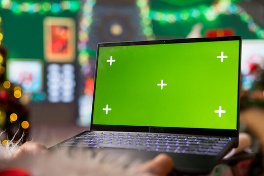 Saint Nicholas using mockup laptop to reply to Christmas requests sent online by children. Santa Claus using green screen notebook to check email inbox for digital letters from kids