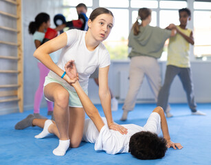 Obraz premium Self-defense - girl twists the arm of an attacking boy during self-defense training
