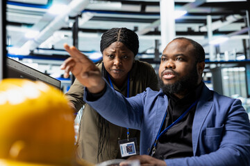 Solar energy specialists team reviewing production line activity on pc, promoting industrial innovation and engineering excellence. Corporate sustainability initiatives for growth.