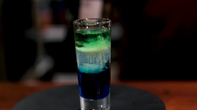 Close up of bartender making layered shots with liqueurs. High quality 4k footage