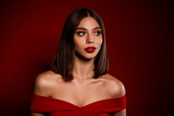 Fototapeta premium Elegant red off shoulder portrait of a young beauty with bold makeup and luxury vibe for holiday branding