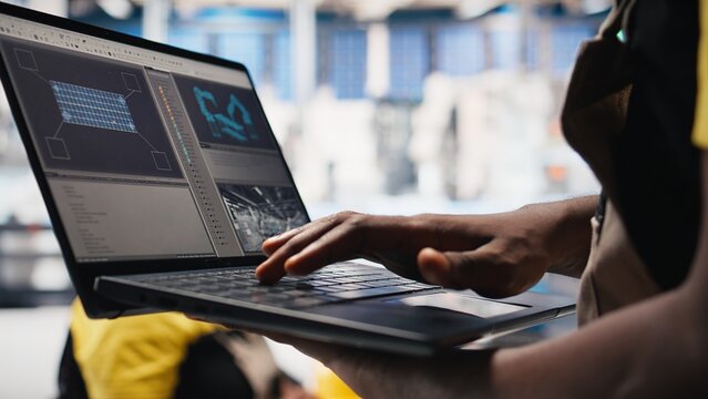 Female technician using laptop to monitor solar panel manufacturing plant production, ensuring sustainable alternative energy at the factory. Troubleshooting photovoltaic equipment. Camera B.
