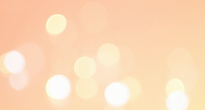 淡いオレンジ色の玉ボケの写真　抽象的な光の背景装飾　エフェクト