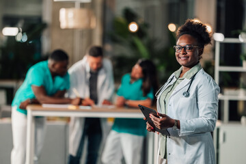 Smiling female doctor holding tablet in hospital setting