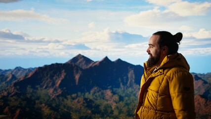 Hiker reaches the top of a mountain and does a victorious pose after a successful climb, reflecting confidence for adventure. Traveler enjoying the personal achievement of conquering fears. Camera A.