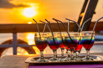 Romantic sunset scene with aperitif glasses on the deck of a luxury cruise ship