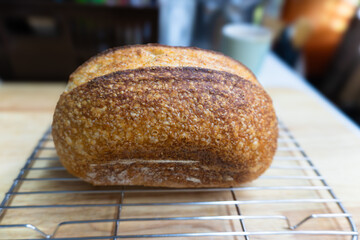Freshly baked brown loaf of bread on a wooden table for a healthy breakfast