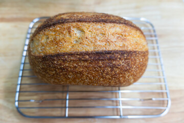 Freshly baked homemade loaf of wheat bread and sliced butter on a wooden table for a healthy breakfast meal