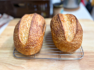 Freshly baked whole wheat loaf of bread on a wooden table, perfect for a healthy breakfast or snack