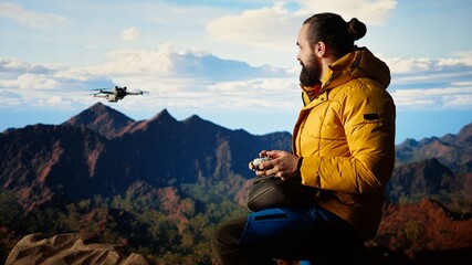 Male influencer shares his hiking journey through a vlog with the drone, recording high quality aerial view content with remote control. Young hiker content creator filming the scenery. Camera A.
