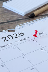 January first 2026 new year calendar date with a pin on wooden background. Close-up. Business goals reminder, annual planning concept.