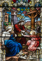Obraz premium Stained glass (19th century) of Holy family: Jesus infant, Virgin Mary and St Joseph in the workshop of Joseph the carpenter.