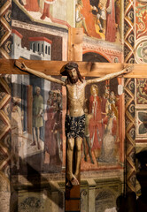 Polychrome Christ crucifix with fresco background.