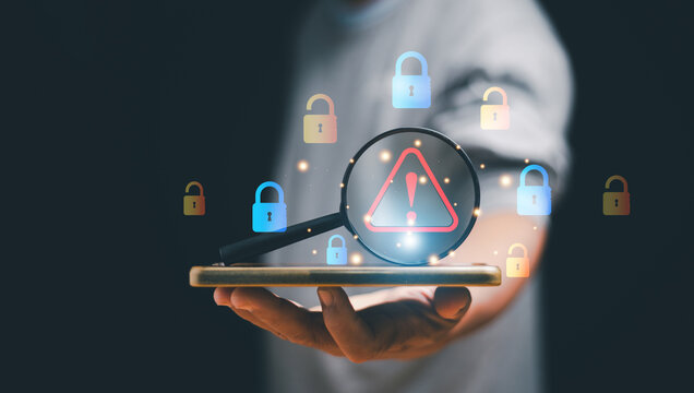 Cybersecurity concept. Man holding smartphone and magnifying glass with a warning sign symbol among colorful padlocks. Representing data protection, threat detection and digital security awareness.