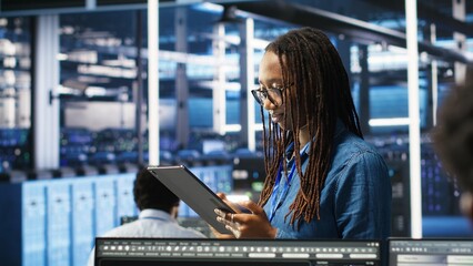 Woman in server hub using AI visualization insights on tablet device to optimize system health. Data center computer scientist analyzing infrastructure issues using node tree tools, camera B