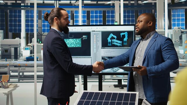 Industrial plant engineers discussing ways to refine designs for increased energy output. Factory employees in workspace collaborating on solar cell prototypes on chroma key notebook, camera A - Powered by Adobe