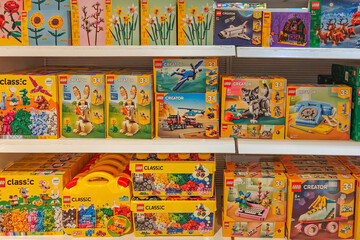 Obraz premium Valencia, Spain - November 18, 2025: LEGO boxes featuring popular series such as LEGO Creator, and LEGO Classic are arranged on toy store shelves. LEGO is Danish brand of plastic building bricks.