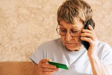 Elderly caucasian woman using smartphone and credit card for online shopping