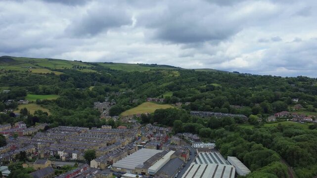 streets of residential houses in Todmorden in West yorkshire next to an industrial area surrounded by hilly Pennine landscape