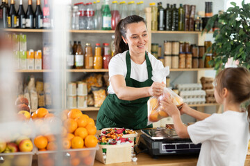 Girl buys ripe apples. Female seller weighs apples on scales