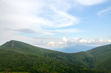 Peaceful mountain scene featuring lush green hills, distant ranges, and a bright blue sky with white clouds. Ideal for nature, travel, and outdoor lifestyle imagery. Carpathian Mountains, Ukraine