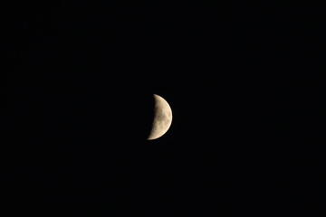 A detailed photograph of the first-quarter moon captured on September 28, 2025, at 7:29 p.m., showing illuminated craters and surface texture against a dark night sky.