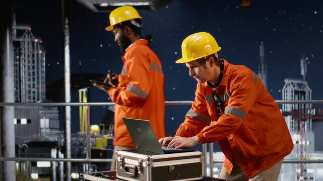 Workers expert concerned on offshore oil platform while he follows fuel extraction using laptop software, sweating and struggling to ensure safe oil drilling production. Camera B.