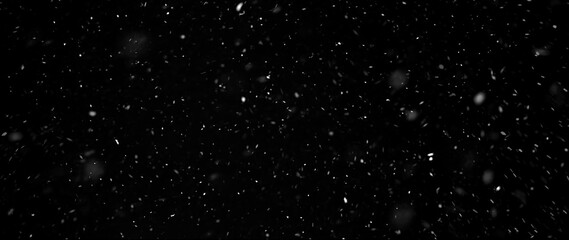Falling snowflakes out of focus on black background for overlay blending mode. Snowing, snowfall, snow on black, selective focus