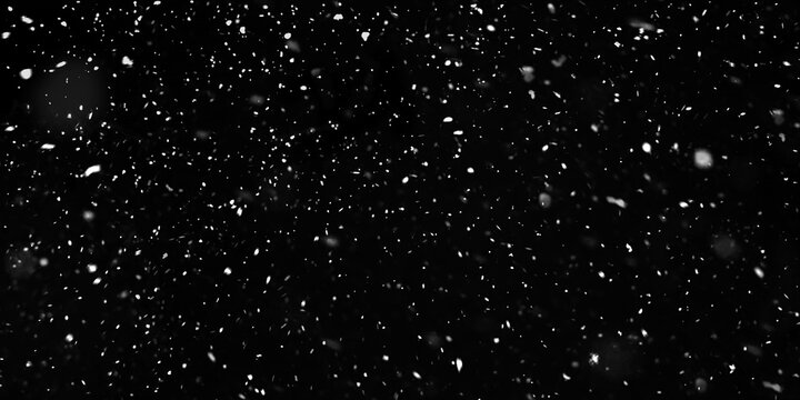 Falling snowflakes out of focus on black background for overlay blending mode. Snowing, snowfall, snow on black, selective focus