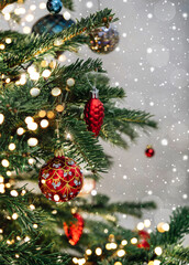 Christmas tree with red decorations on light background with bokeh, sparking, glowing. Merry Christmas and Happy New Year greeting card. Xmas and Winter holidays. Christmas wide banner