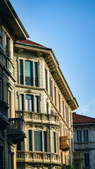 Balconies in the historic district of Milan, Italy, illuminated by warm sunset light, with ornate architecture and romantic atmosphere