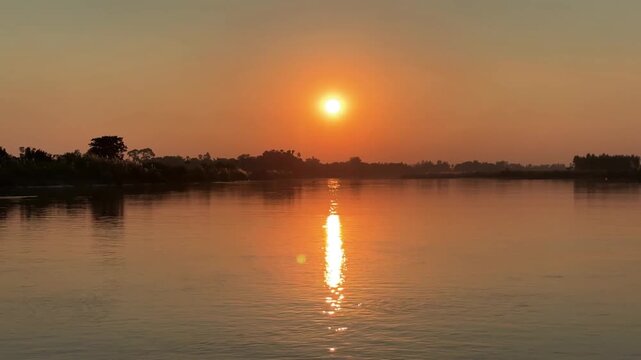 Golden sunset reflecting on a tranquil river surface creating a peaceful and serene atmosphere perfect for relaxation and travel inspiration