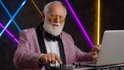 Elderly man DJ with white beard and sunglasses wearing patterned pink jacket, joyful confident groove mixing music laptop, mixer, headphones neon - Powered by Adobe